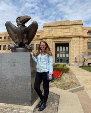 Josie Chandler standing in front of Strong Hall by the bronze Jayhawk Statue